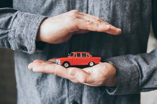 Male,Hands,Holding,And,Protecting,A,Red,Toy,Car.,Conceptual