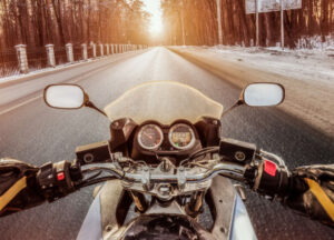 A motorcycle rider driving on a winter road in Texas.