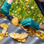 A man cleaning his gutters to prepare his North Texas home for winter.