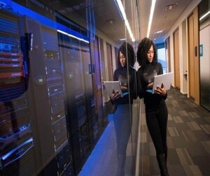 A woman on a device near servers.