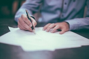 A man signing a home insurance policy that covers mold.