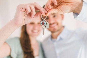 happy couple holding keys to their house